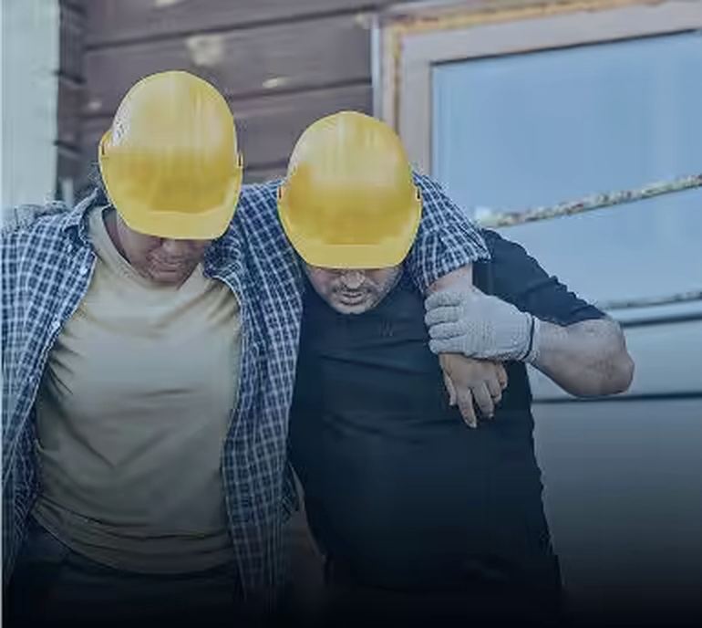 An injured worker being helped from a job site